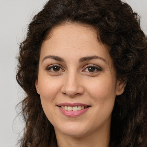 Joyful white adult female with long  brown hair and brown eyes