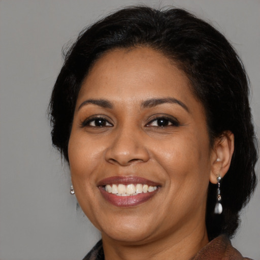 Joyful latino adult female with medium  brown hair and brown eyes