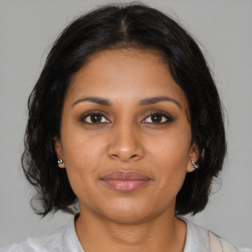 Joyful black young-adult female with medium  brown hair and brown eyes