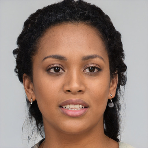 Joyful black young-adult female with long  black hair and brown eyes