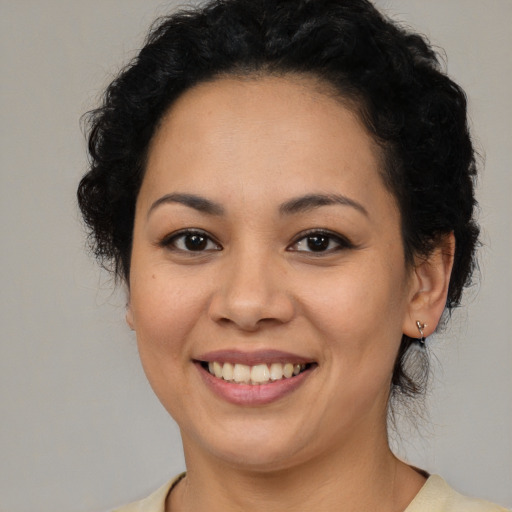 Joyful latino young-adult female with medium  brown hair and brown eyes