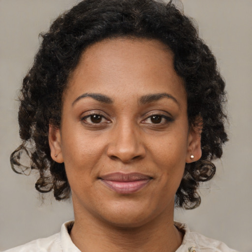 Joyful black young-adult female with medium  brown hair and brown eyes