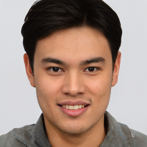 Joyful asian young-adult male with short  brown hair and brown eyes