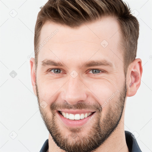 Joyful white young-adult male with short  brown hair and grey eyes