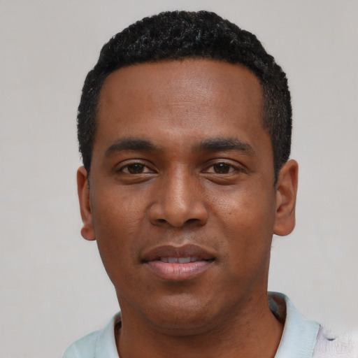 Joyful black young-adult male with short  black hair and brown eyes