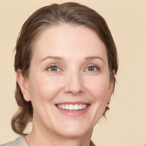 Joyful white adult female with medium  brown hair and grey eyes