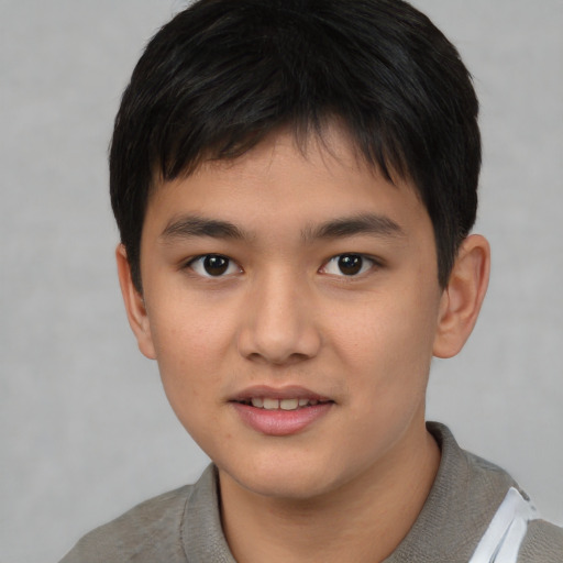 Joyful asian child male with short  brown hair and brown eyes