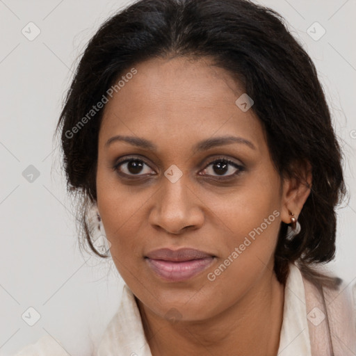 Joyful black adult female with long  brown hair and brown eyes