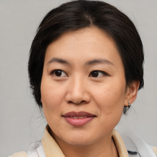Joyful asian adult female with medium  brown hair and brown eyes