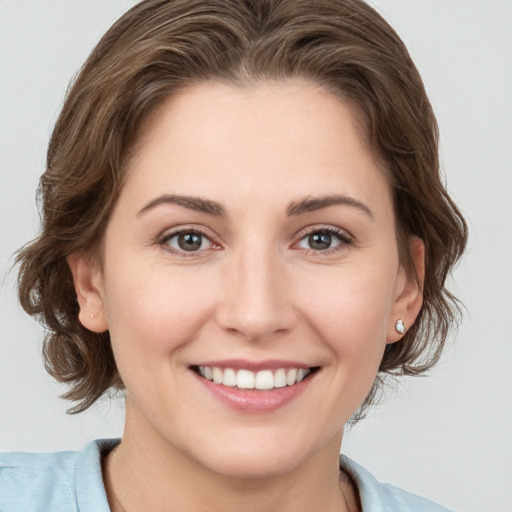 Joyful white young-adult female with medium  brown hair and grey eyes