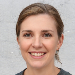 Joyful white young-adult female with medium  brown hair and grey eyes