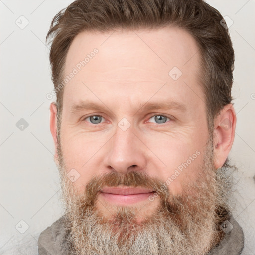 Joyful white adult male with short  brown hair and grey eyes