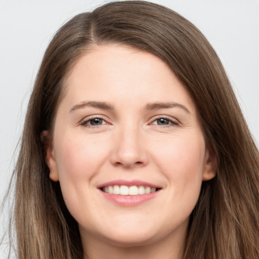 Joyful white young-adult female with long  brown hair and brown eyes