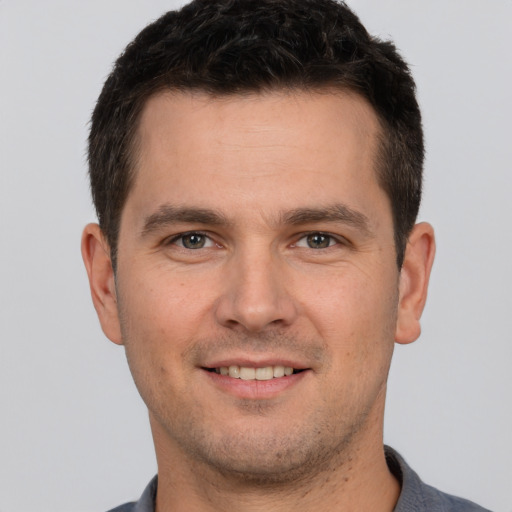 Joyful white young-adult male with short  brown hair and brown eyes