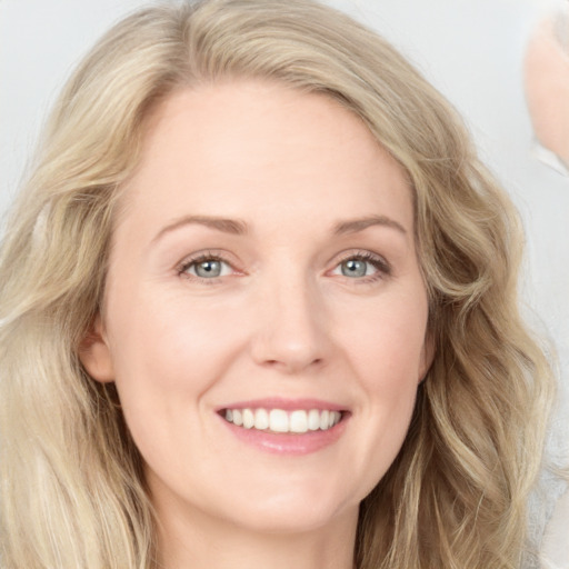 Joyful white young-adult female with long  brown hair and blue eyes