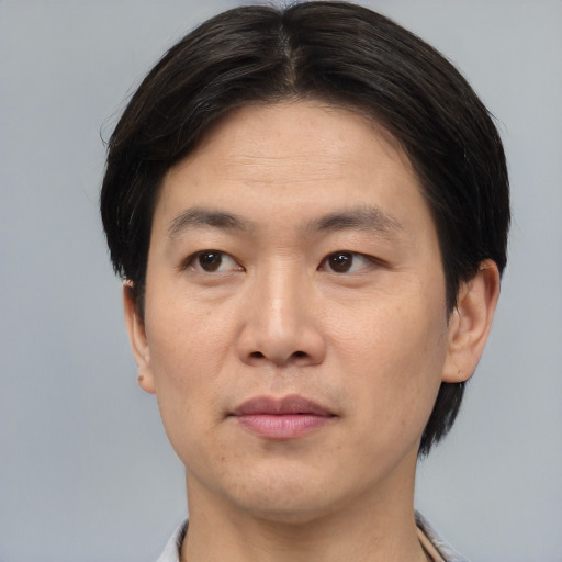Joyful asian young-adult male with short  brown hair and brown eyes