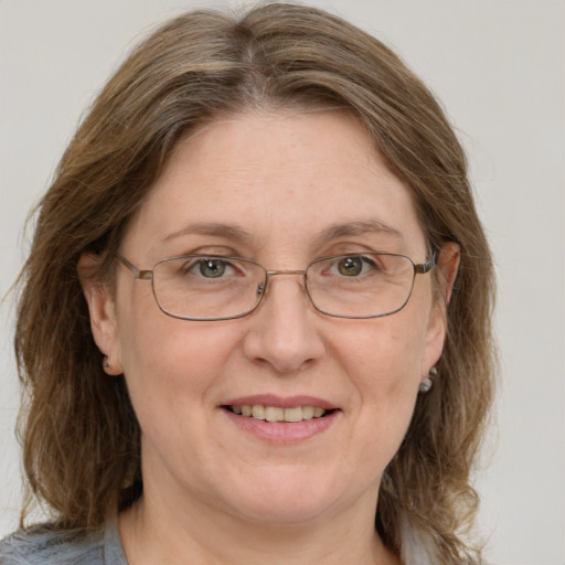 Joyful white adult female with medium  brown hair and blue eyes