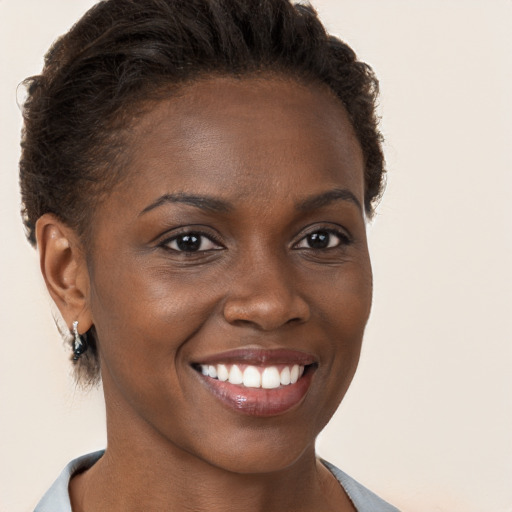 Joyful black young-adult female with short  brown hair and brown eyes