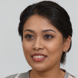 Joyful latino young-adult female with medium  brown hair and brown eyes