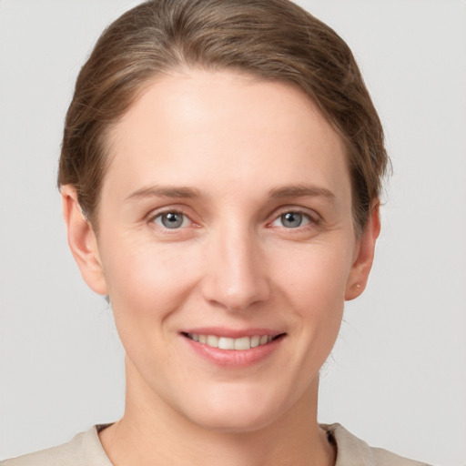 Joyful white young-adult female with short  brown hair and grey eyes