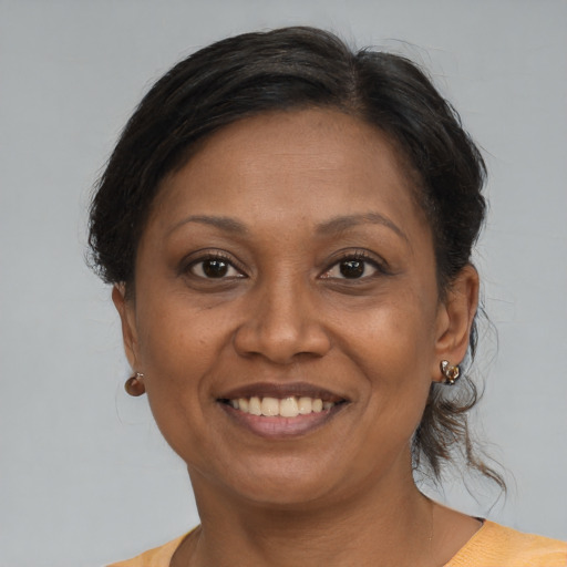 Joyful black adult female with medium  brown hair and brown eyes