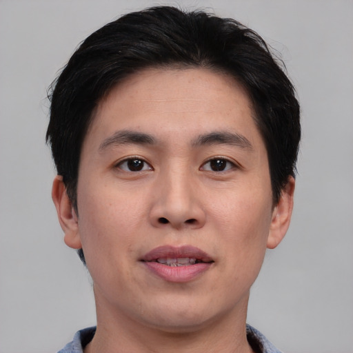 Joyful asian young-adult male with short  black hair and brown eyes