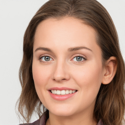 Joyful white young-adult female with long  brown hair and grey eyes