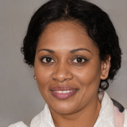 Joyful black adult female with medium  brown hair and brown eyes