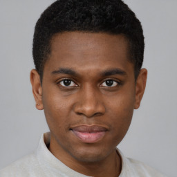 Joyful black young-adult male with short  brown hair and brown eyes