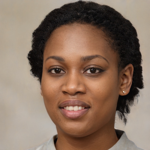 Joyful black young-adult female with short  black hair and brown eyes
