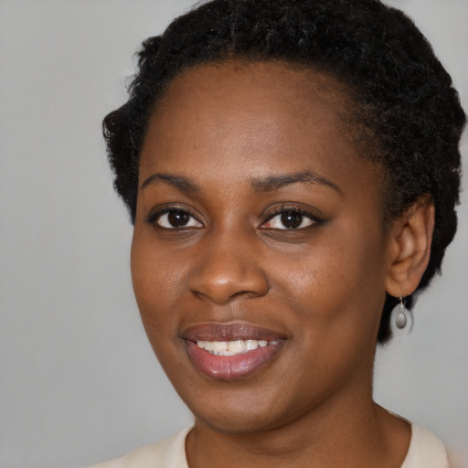 Joyful black young-adult female with short  brown hair and brown eyes