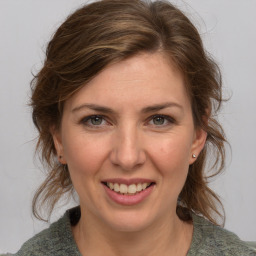 Joyful white young-adult female with medium  brown hair and blue eyes