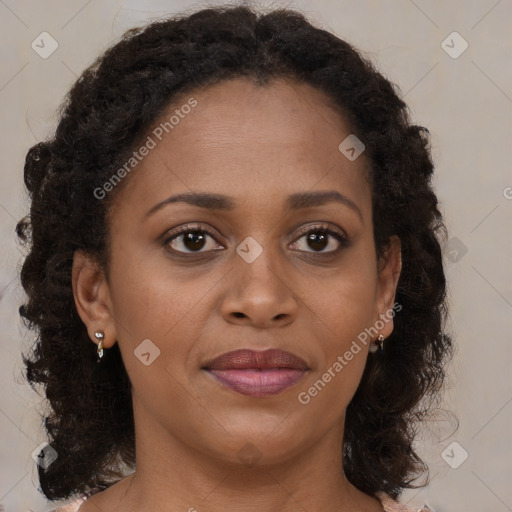 Joyful black adult female with long  brown hair and brown eyes