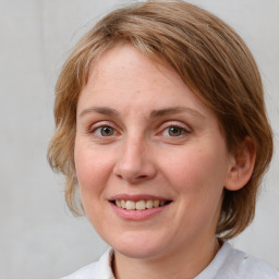 Joyful white adult female with medium  brown hair and blue eyes