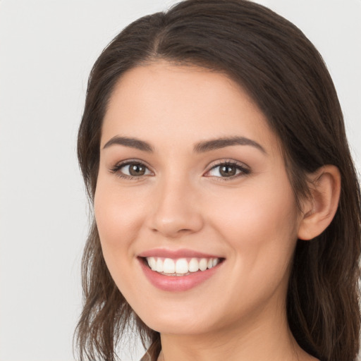 Joyful white young-adult female with long  brown hair and brown eyes