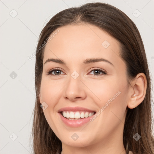 Joyful white young-adult female with long  brown hair and brown eyes