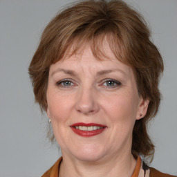 Joyful white adult female with medium  brown hair and blue eyes