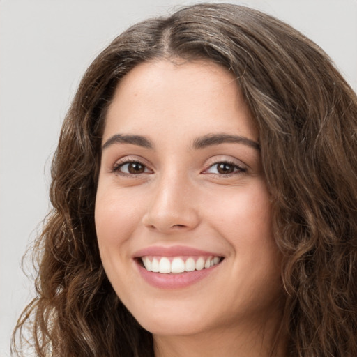 Joyful white young-adult female with long  brown hair and green eyes