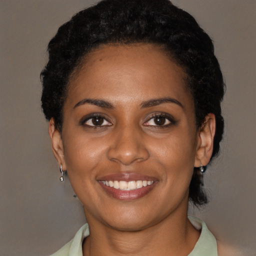 Joyful black young-adult female with short  black hair and brown eyes