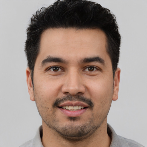 Joyful latino young-adult male with short  black hair and brown eyes