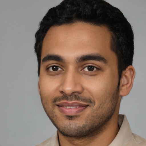 Joyful latino young-adult male with short  black hair and brown eyes