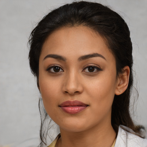 Joyful latino young-adult female with medium  brown hair and brown eyes