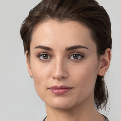 Joyful white young-adult female with medium  brown hair and grey eyes