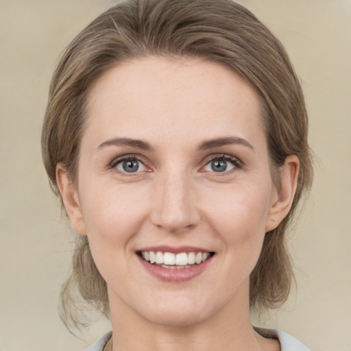 Joyful white young-adult female with medium  brown hair and green eyes