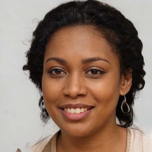 Joyful black young-adult female with long  black hair and brown eyes