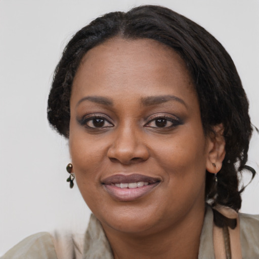Joyful black young-adult female with long  black hair and brown eyes