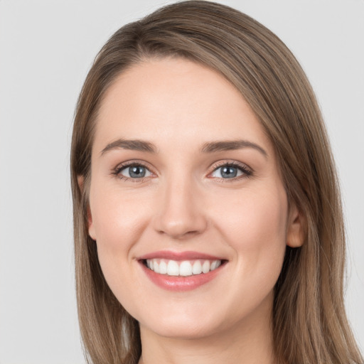 Joyful white young-adult female with long  brown hair and grey eyes