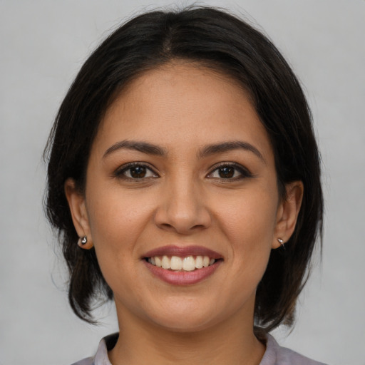 Joyful latino young-adult female with medium  brown hair and brown eyes