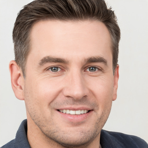 Joyful white young-adult male with short  brown hair and brown eyes