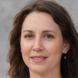 Joyful white adult female with long  brown hair and brown eyes